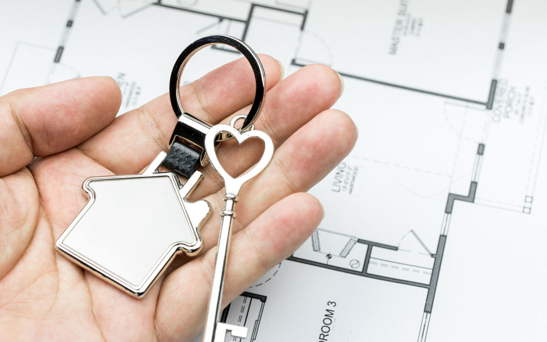homeowner holding keys above house plan